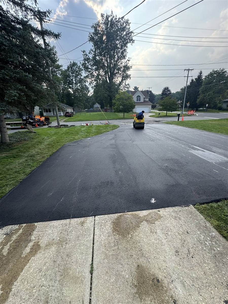 Roller finishing a residential sealcoat refresh