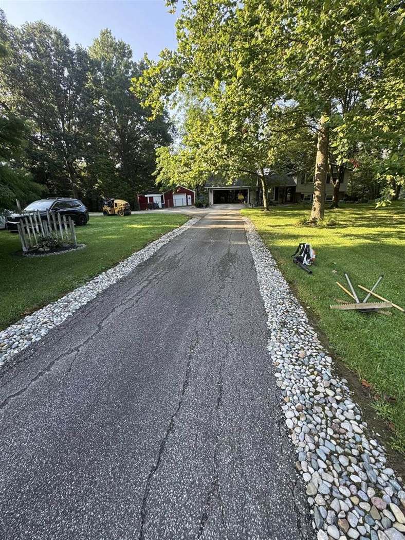 Rural driveway lined with decorative stone borders